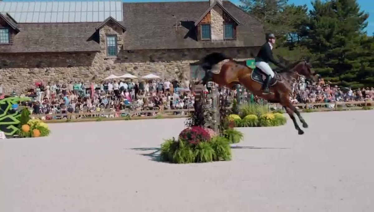 Horse and rider clearing a fence in front of the clubhouse at Greenwich Polo Club