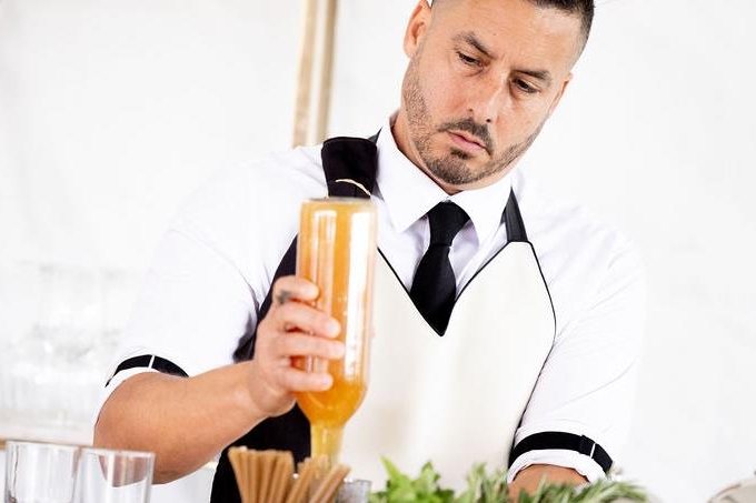 A bartender pouring a cocktail at the hospitality bar